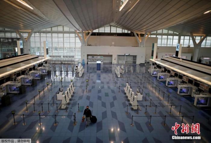 資料圖：日本東京，東京國際機場，一名乘客在國際航班航站樓的登機區(qū)。