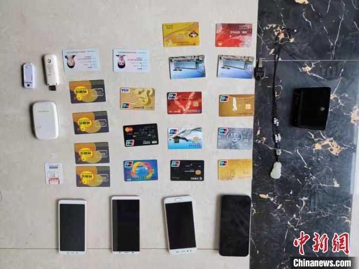 資料圖為果洛藏族自治州公安民警查扣的作案手機(jī)和涉案銀行卡?！‖斍呖h公安局供圖
