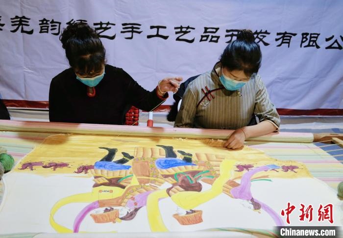 圖為皮繡藝人在市集上“秀”指尖技藝。　馬銘言 攝