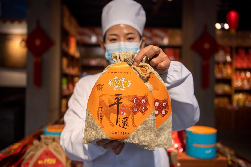 1月27日，在平遙古城南大街的一家平遙牛肉店內(nèi)，工作人員展示一款牛肉產(chǎn)品。新華社記者 楊晨光 攝