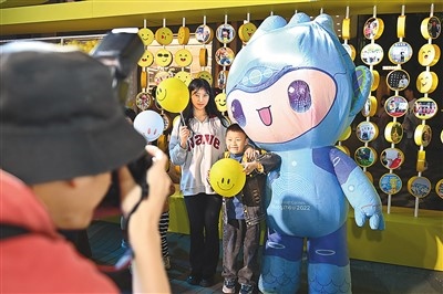 5月7日，在浙江省杭州市湖濱步行街“3D笑臉墻”前，攝影師為游客與杭州亞運(yùn)會(huì)吉祥物之一“宸宸”拍攝合影。