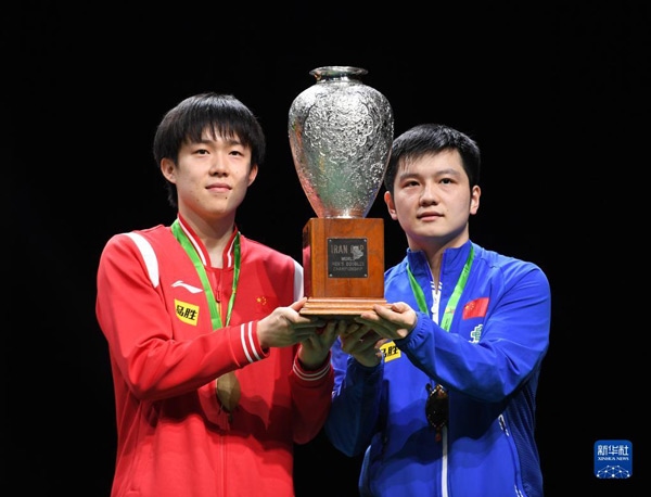5月27日，樊振東（右）/王楚欽在頒獎(jiǎng)儀式上高舉獎(jiǎng)杯慶祝。當(dāng)日，在南非德班進(jìn)行的2023年世界乒乓球錦標(biāo)賽男雙決賽中，中國組合樊振東/王楚欽以3比0戰(zhàn)勝韓國組合張禹珍/林鐘勛，奪得冠軍。新華社記者 李亞輝攝