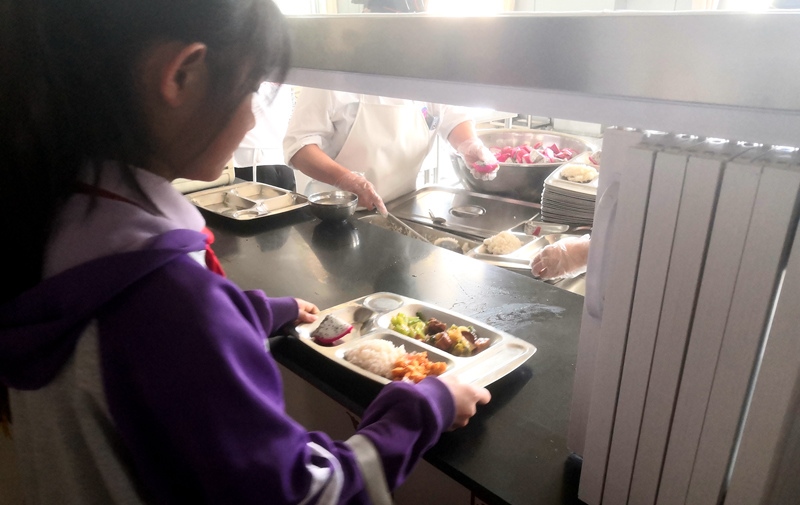 伊金霍洛旗第一小學(xué)學(xué)生正在打飯，今天的飯菜是三菜一湯外加水果，學(xué)生可以多次盛取，吃飽為止。人民網(wǎng)記者 孫博洋攝