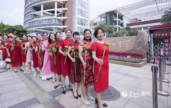 6月7日一早，廈門雙十中學考生家長們身穿旗袍，手拿向日葵在考場外為孩子加油打氣，寓意“旗開得勝，一舉奪魁”。人民網(wǎng)記者 陳博攝