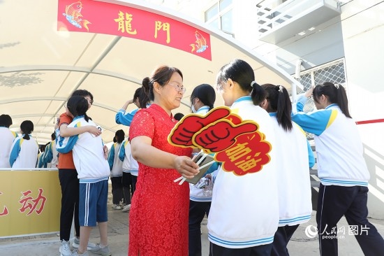 6月7日一早，雄安新區(qū)安新中學老師在給同學們加油鼓勁兒。人民網(wǎng) 李兆民攝