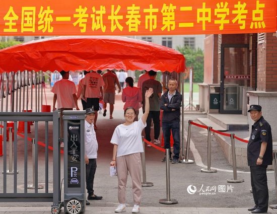 6月7日，在長春市第二中學考點，一名考生信心滿滿進入考場，并與家長揮手致意。人民網(wǎng)記者 李洋攝