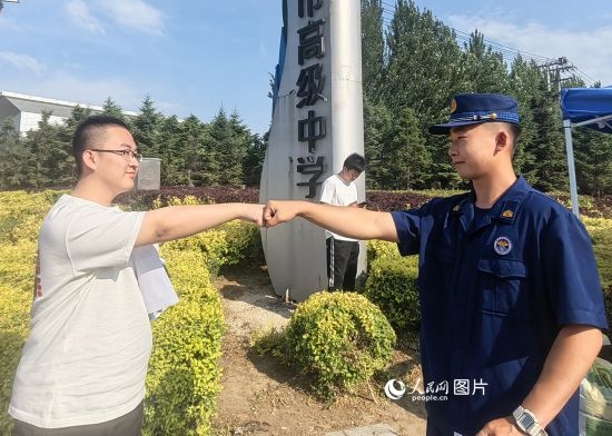 6月7日，遼寧營口老邊區(qū)消防救援大隊的消防員為高考學子加油助威。人民網(wǎng)記者 尹柏寒攝