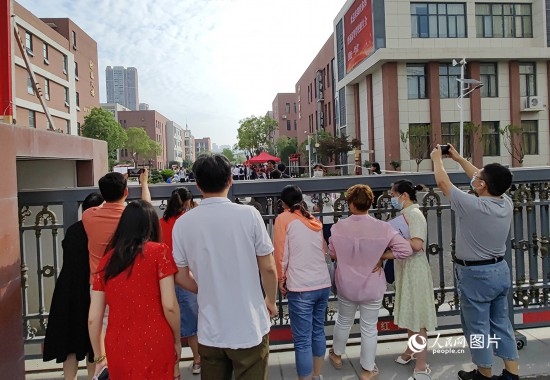 6月7日，武漢市第三中學考點，考生進場后，家長在柵欄外用手機拍攝自己的孩子。人民網(wǎng)記者 郭婷婷攝