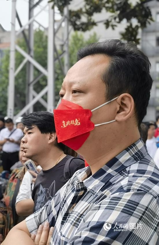 6月7日早，在武漢市第二十六中學考點外，送考家長戴著印有“金榜題名”的口罩。人民網(wǎng) 周雯攝