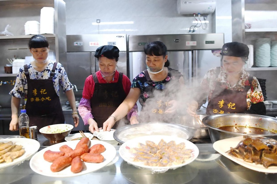 福建三明市沙縣區(qū)一家小吃店工作人員在為客人準(zhǔn)備特色小吃。 新華社記者 林善傳 攝