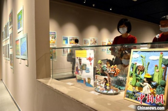圖為家長(zhǎng)帶著孩子參觀展覽。呂明 攝