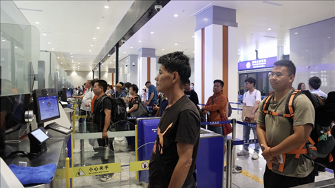 6月13日，乘坐中老鐵路國際旅客列車的旅客在磨憨邊檢大廳排隊候檢。李揚 攝