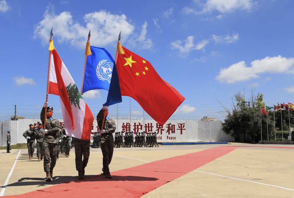 在黎巴嫩南部辛尼亞村的中國維和部隊營區(qū)，中國維和部隊官兵在受勛后通過觀禮臺（2022年7月1日攝）。聯(lián)合國駐黎巴嫩臨時部隊（聯(lián)黎部隊）當(dāng)日授予中國第20批赴黎巴嫩維和部隊全體410名官兵聯(lián)合國“和平勛章”，以表彰他們?yōu)槔璋湍勰喜康貐^(qū)和平穩(wěn)定作出的突出貢獻。新華社記者 劉宗亞 攝