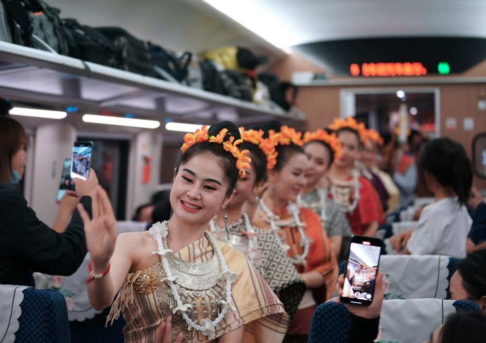 2023年4月13日，老撾工作人員在D887次國際旅客列車上表演。當(dāng)日，中老鐵路從中國昆明南站、老撾萬象站雙向?qū)﹂_D887次和D888次國際旅客列車，兩地乘火車可當(dāng)日通達。中老鐵路是高質(zhì)量共建“一帶一路”的標(biāo)志性工程。新華社記者 邢廣利 攝