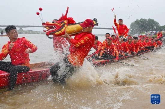 6月22日，在湖南省岳陽(yáng)市湘陰縣湘江臨資口水域，參加龍舟賽的隊(duì)員接“龍頭”下水。