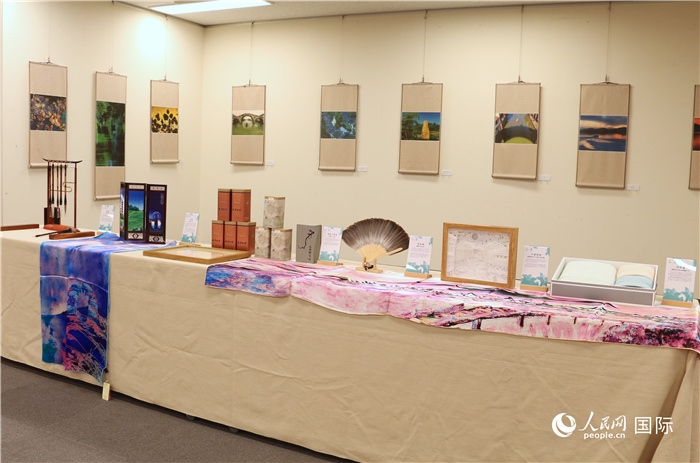 現(xiàn)場展出的馮學敏攝影作品與湖州市特色工藝品。（人民網(wǎng) 許可攝）
