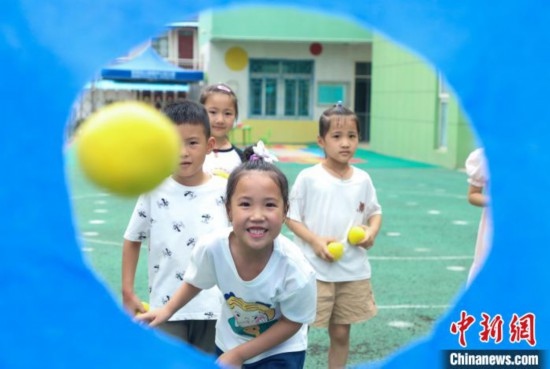 在肥西縣山南鎮(zhèn)中心幼兒園，孩子們在玩布洞投球游戲。陳家樂 攝
