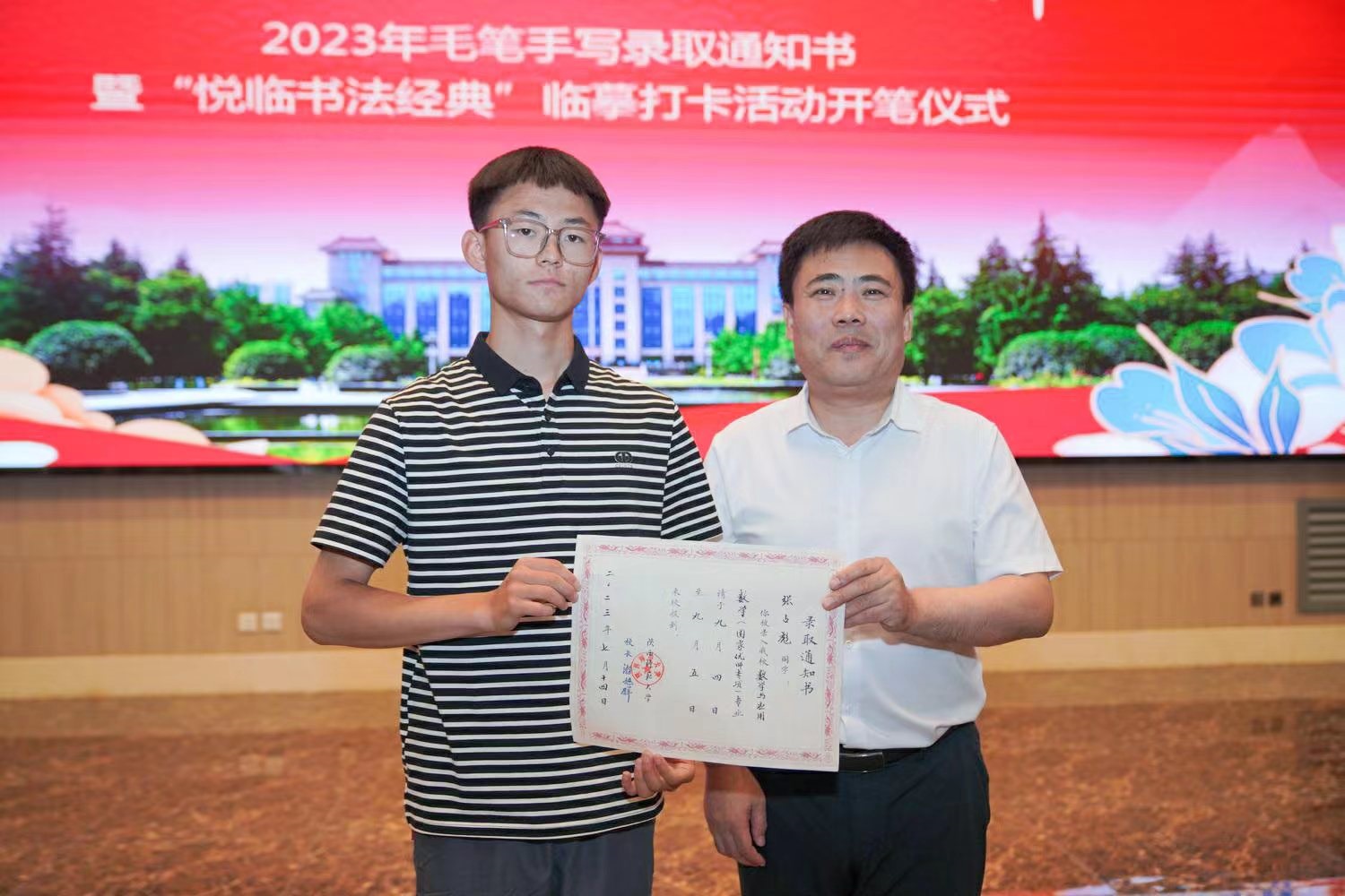 陜西師范大學(xué)黨委書記李忠軍為2023級新生代表張占彪同學(xué)發(fā)放錄取通知書。校方供圖