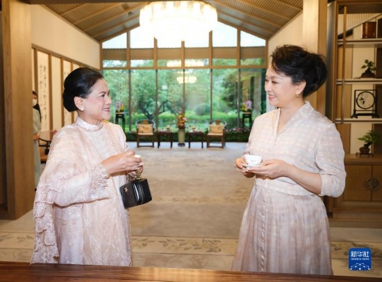  7月27日下午，國家主席習(xí)近平夫人彭麗媛在四川成都會見陪同印度尼西亞總統(tǒng)佐科來華出席第31屆世界大學(xué)生夏季運動會開幕式并訪華的總統(tǒng)夫人伊莉亞娜。這是彭麗媛邀請伊莉亞娜觀看茶藝表演，并同伊莉亞娜親切茶敘。新華社記者 丁林 攝