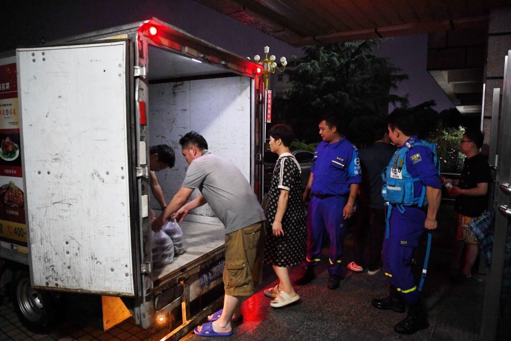 河北省涿州市職教中心安置點的工作人員在運送飯菜，準備發(fā)放給安置群眾（8月1日攝）。新華社記者 牟宇 攝