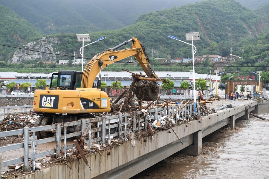 8月1日，在北京市門頭溝區(qū)水峪嘴村村口，一臺挖掘機在清理阻斷橋梁交通的雜物。目前該條道路已經疏通完成。新華社記者 鞠煥宗 攝