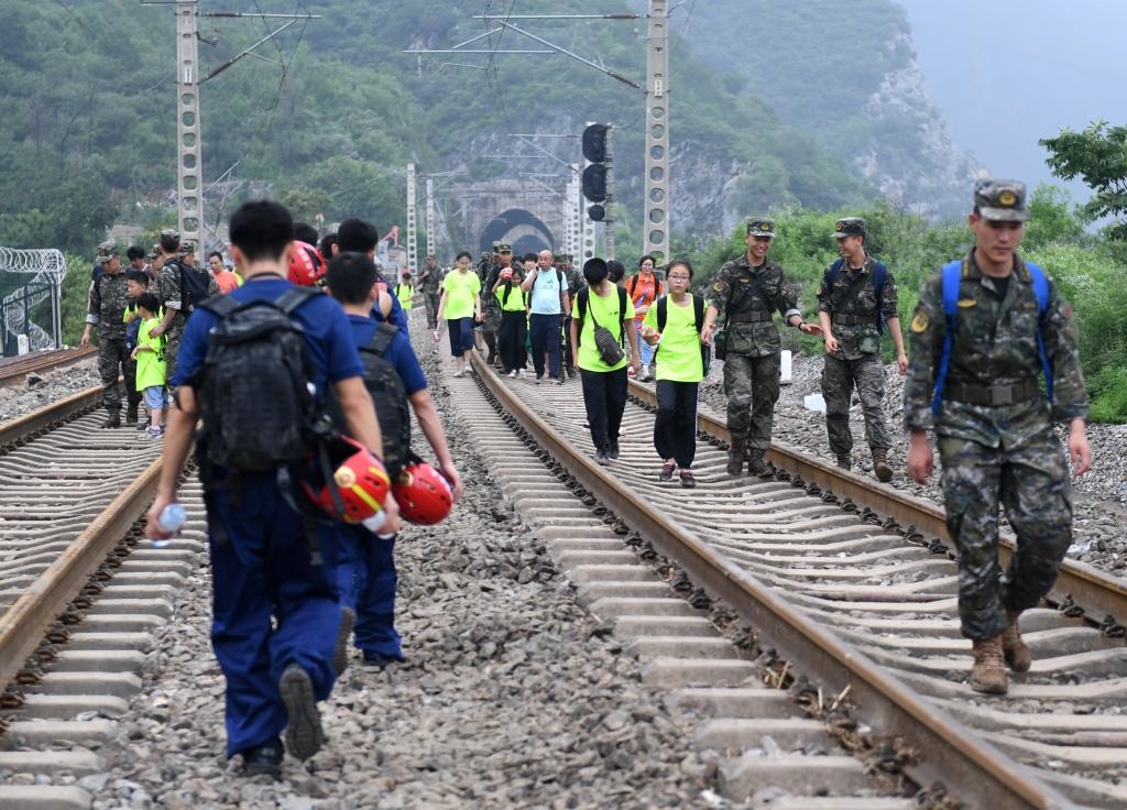 8月2日，部分滯留在北京市門頭溝山區(qū)受困列車的旅客，在救援人員幫助下前往轉(zhuǎn)運(yùn)客車。新華社記者張晨霖 攝