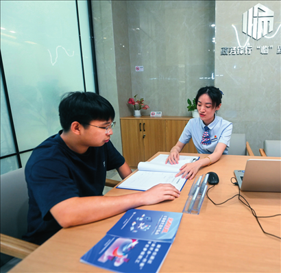 在杭州市臨安區(qū)政務服務中心的“為企服務中心”，黨員志愿者（右）解答企業(yè)主的疑問（2023年7月7日攝）。徐昱攝/本刊