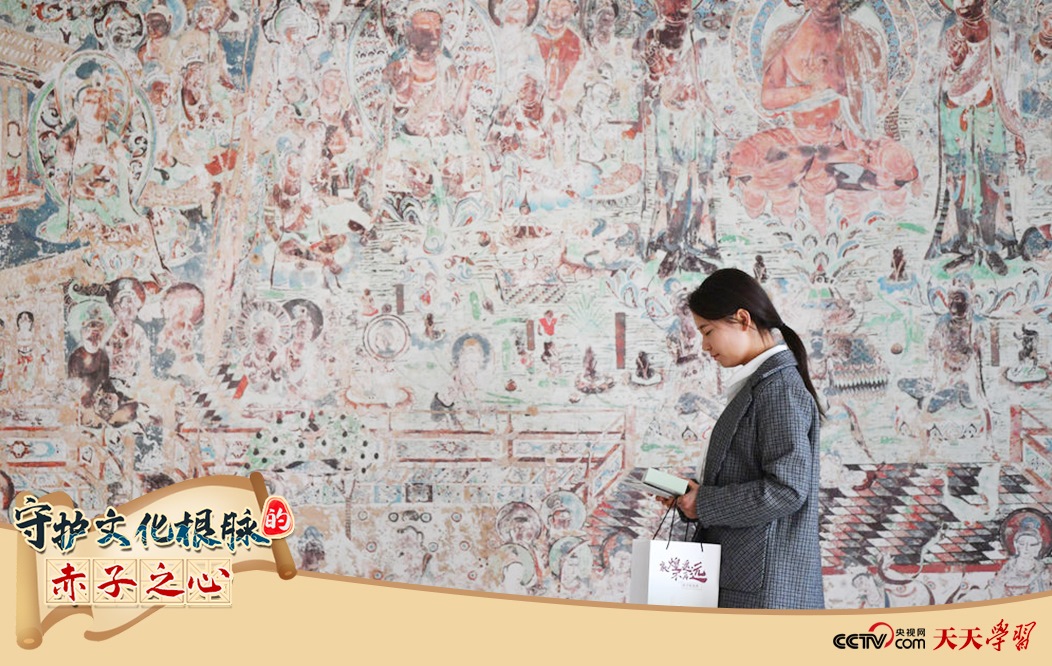 2023年4月25日，敦煌研究院文物數(shù)字化保護(hù)團(tuán)隊(duì)創(chuàng)意營(yíng)銷人員廖雪婷從一幅高保真復(fù)制壁畫(huà)前走過(guò)。