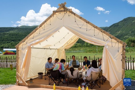 8月12日，游客在寧夏固原市涇源縣大灣鄉(xiāng)楊嶺村品嘗當地美食。新華社記者 李旭倫 攝