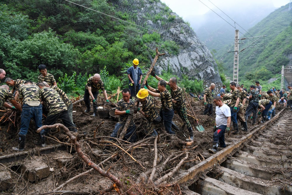 8月1日，在北京市門頭溝區(qū)水峪嘴村附近一段被阻斷的鐵路線上，中鐵六局工作人員在清理軌道上的雜物，全力恢復(fù)交通。新華社記者 鞠煥宗 攝