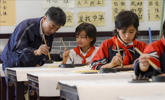 △新疆疏附縣托克扎克鎮(zhèn)中心小學書法教室內(nèi)，同學們正在學習寫毛筆字。