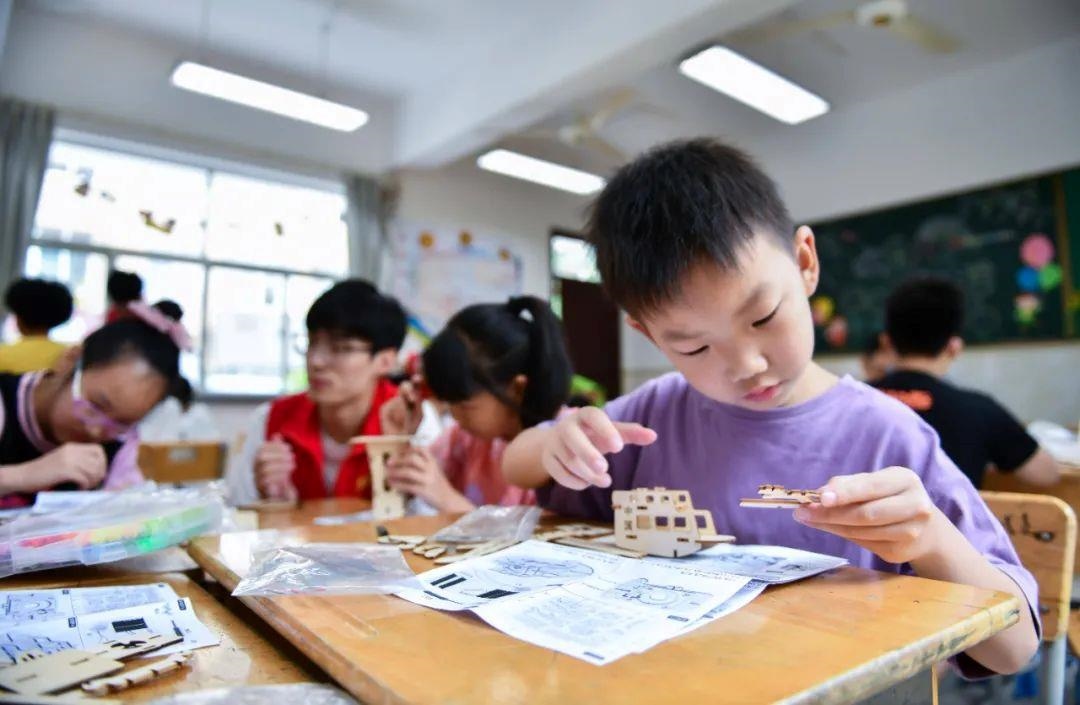 △今年7月，在浙江余姚市舜北小學暑托班內(nèi)，孩子們制作太陽能科學實驗裝置。