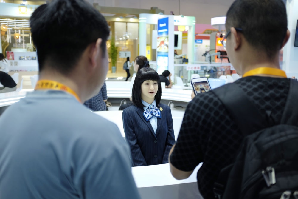9月1日，媒體記者在國家會議中心與服務機器人互動。新華社記者 劉夢琪 攝