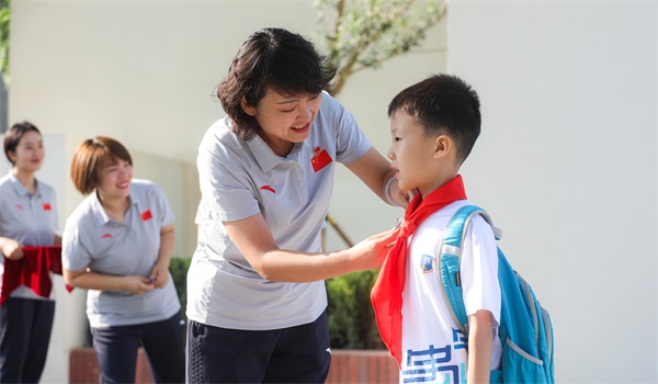 8月30日，雄安史家胡同小學(xué)學(xué)生體驗(yàn)學(xué)校生活。老師為學(xué)生佩戴?；?。