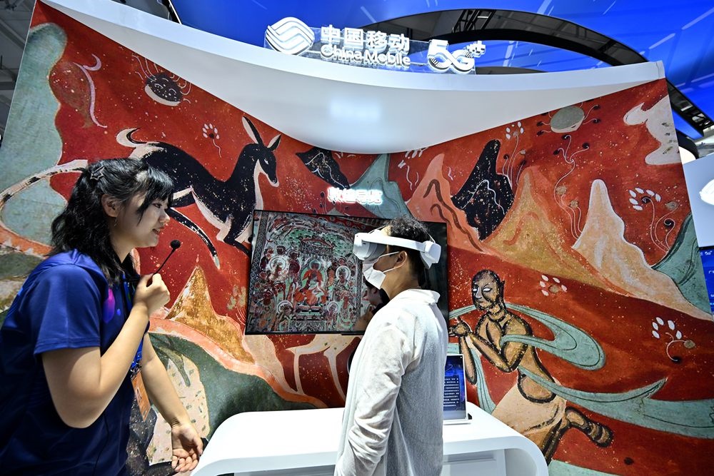 9月3日，一名參觀者在首鋼園中國移動展臺體驗基于AR/VR特效的敦煌導(dǎo)覽，沉浸式感受敦煌壁畫的魅力。新華社記者 李鑫 攝