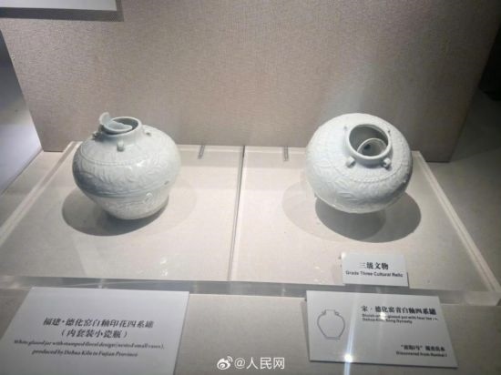 福建德化窯白釉印花四系罐（左）。人民網記者 李娜攝
