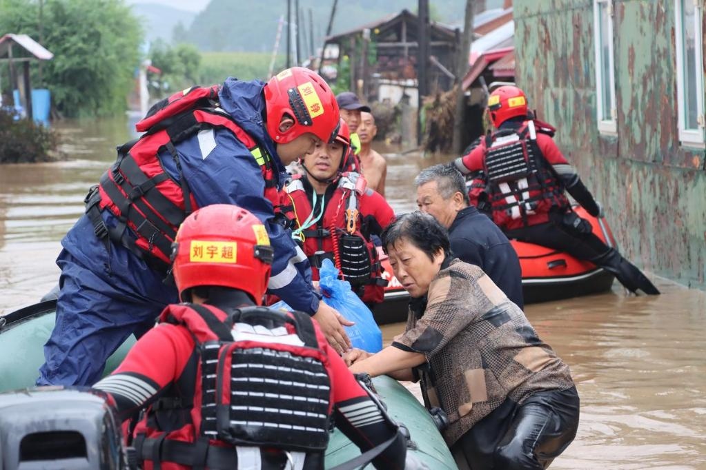8月4日，在黑龍江省尚志市一面坡鎮(zhèn)萬(wàn)山村，哈爾濱市森林消防支隊(duì)的消防員在解救被困村民。新華社發(fā)