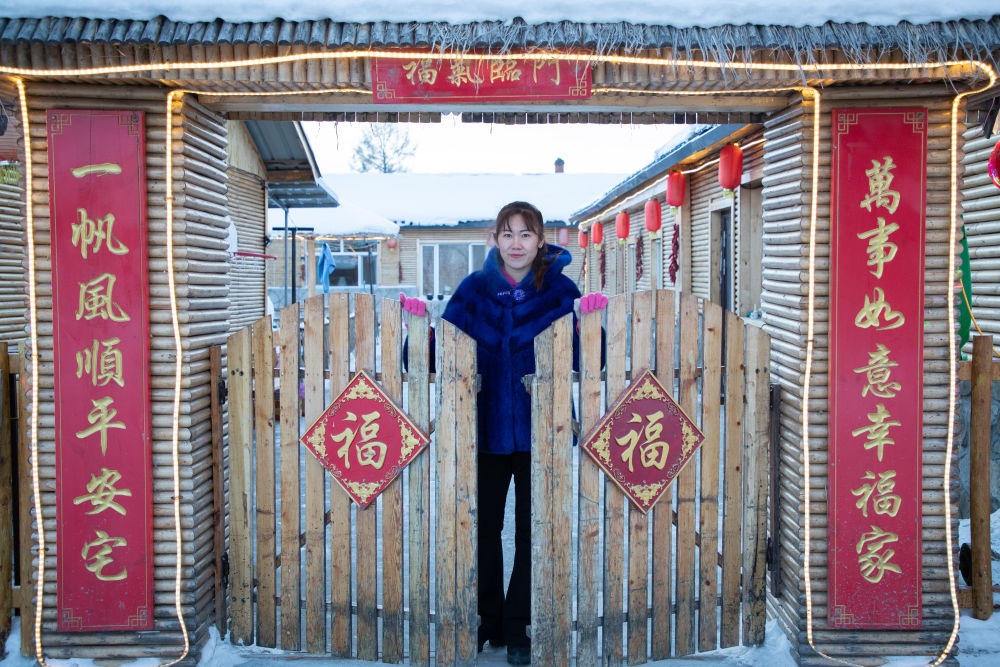 北極村民宿經(jīng)營(yíng)者史瑞娟在門前迎候入住的游客（2023年1月7日攝）。