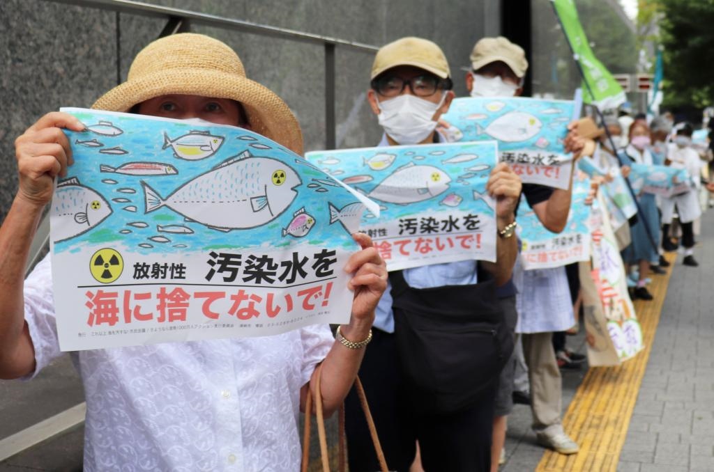 8月24日，日本民眾手持“不要將污染水扔進(jìn)大?！钡葮?biāo)語在東京電力公司總部前集會，抗議日本政府和東電公司無視民意啟動(dòng)核污染水排海。新華社記者楊光攝