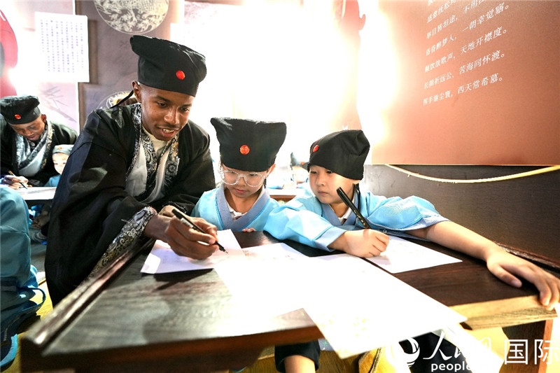 圖為選手與同學(xué)們一起寫書法。人民網(wǎng) 盧鵬宇攝