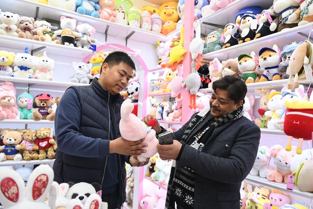 2023年2月2日，來自印度的客商（右）在義烏國際商貿(mào)城的一家玩具店鋪內(nèi)選購商品。新華社記者 黃宗治 攝