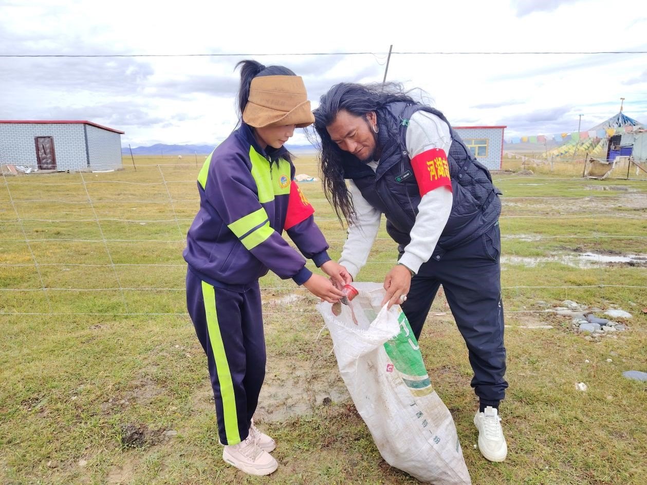 玉樹州稱多縣珍秦鎮(zhèn)河湖志愿者才培和他女兒更求拉毛在清掃垃圾。受訪者供圖