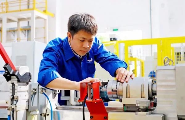 △鄭志明正在對襯套自動壓裝設備進行檢測調(diào)試。