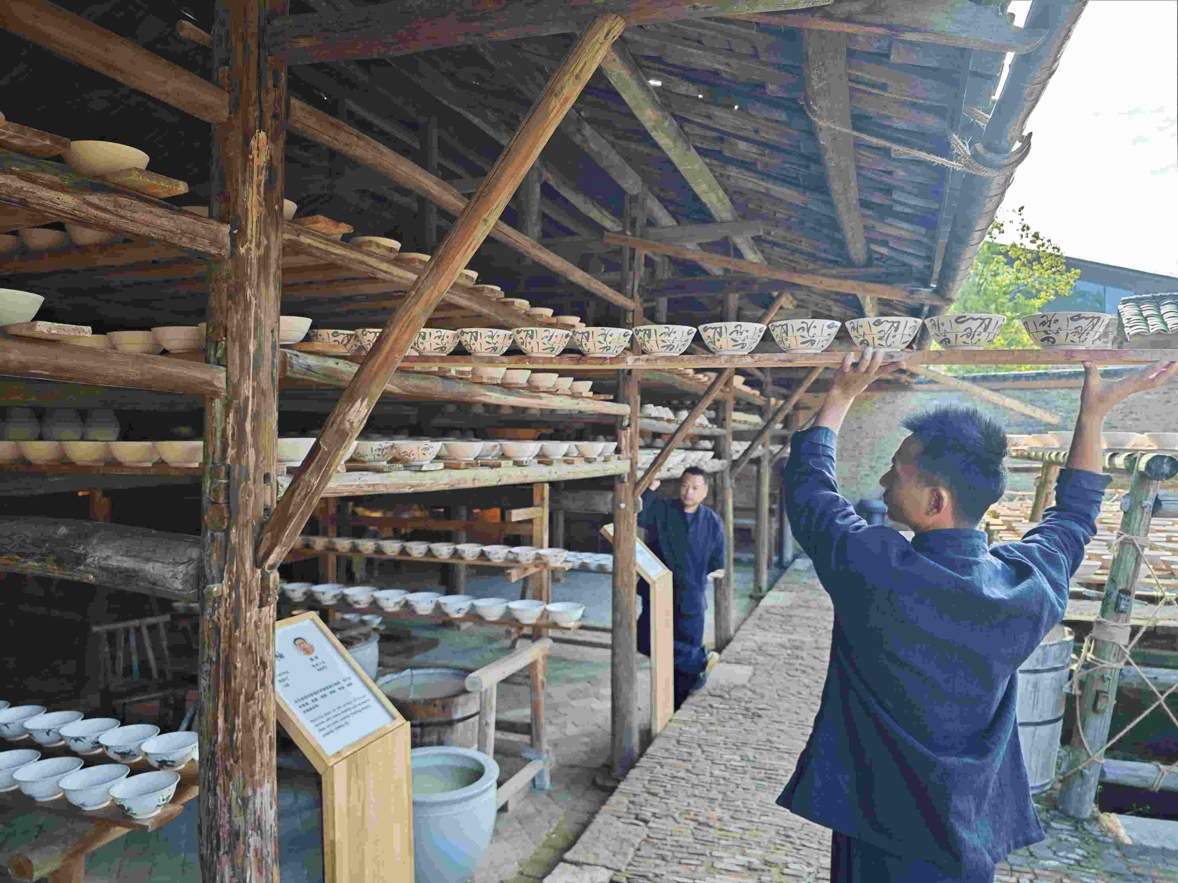 △陶陽(yáng)里歷史文化街區(qū)里，工匠將陶瓷工藝品放到架上晾干。（總臺(tái)央視記者彭漢明拍攝）