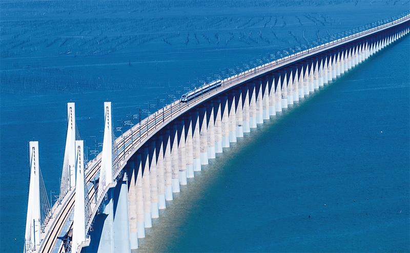 2023年9月28日，中國首條時速350公里跨海高鐵——福廈高鐵正式開通運(yùn)營。圖為一列運(yùn)行試驗車組駛過福廈高鐵湄洲灣跨海大橋（9月19日攝，無人機(jī)照片）。 新華社記者 魏培全/攝