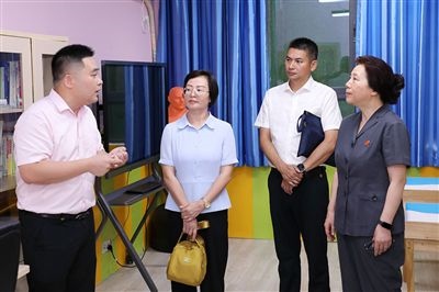 圖③：“小公民法律課堂”開(kāi)講前，全國(guó)人大代表殷其龍（右二）、重慶市人大代表李自玲（左二）聽(tīng)取楊家坪中學(xué)負(fù)責(zé)人關(guān)于未成年人思想教育工作情況的介紹。