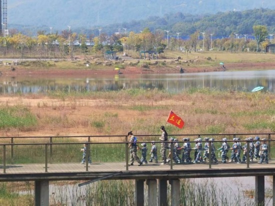 10月24日，秋游的幼兒園小朋友在老師帶領(lǐng)下走在清水塘公園里的木橋上。本報(bào)記者 常雯宜攝
