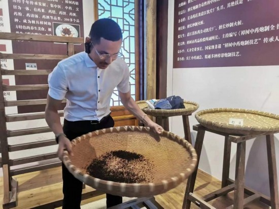 2023“一帶一路”媒體合作論壇聯(lián)合采訪團(tuán)團(tuán)員在非遺文化展示館體驗(yàn)中藥炮制技藝。（本報(bào)記者 黃超攝）