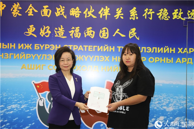 11月10日，沈敏娟大使向蒙古國(guó)公民尼亞姆庫(kù)（右）頒發(fā)最后一份領(lǐng)事認(rèn)證書(shū)。人民網(wǎng)記者 霍文攝