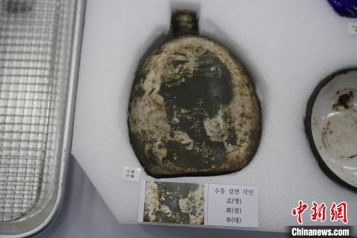 當(dāng)?shù)貢r(shí)間11月22日上午，第十批在韓中國(guó)人民志愿軍烈士遺骸裝殮儀式在韓國(guó)舉行。圖為裝殮儀式現(xiàn)場(chǎng)拍攝的寫(xiě)有“孟廣泰”名字的水壺。中新社記者劉旭 攝